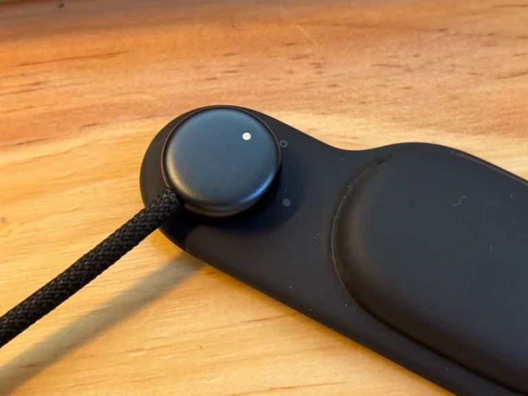 Une image apparaît du connecteur de charge et du ruban de fixation d'un Vision Pro en noir